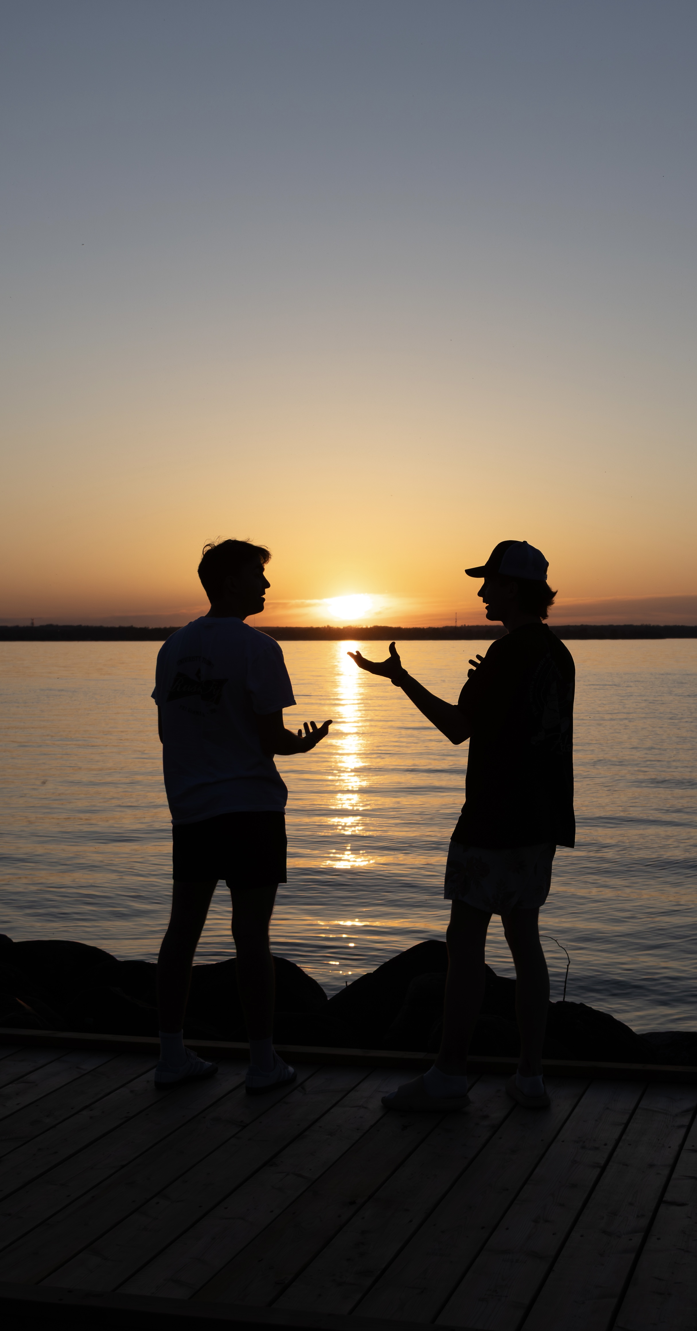 Talking with a friend at sunset on a dock by the water