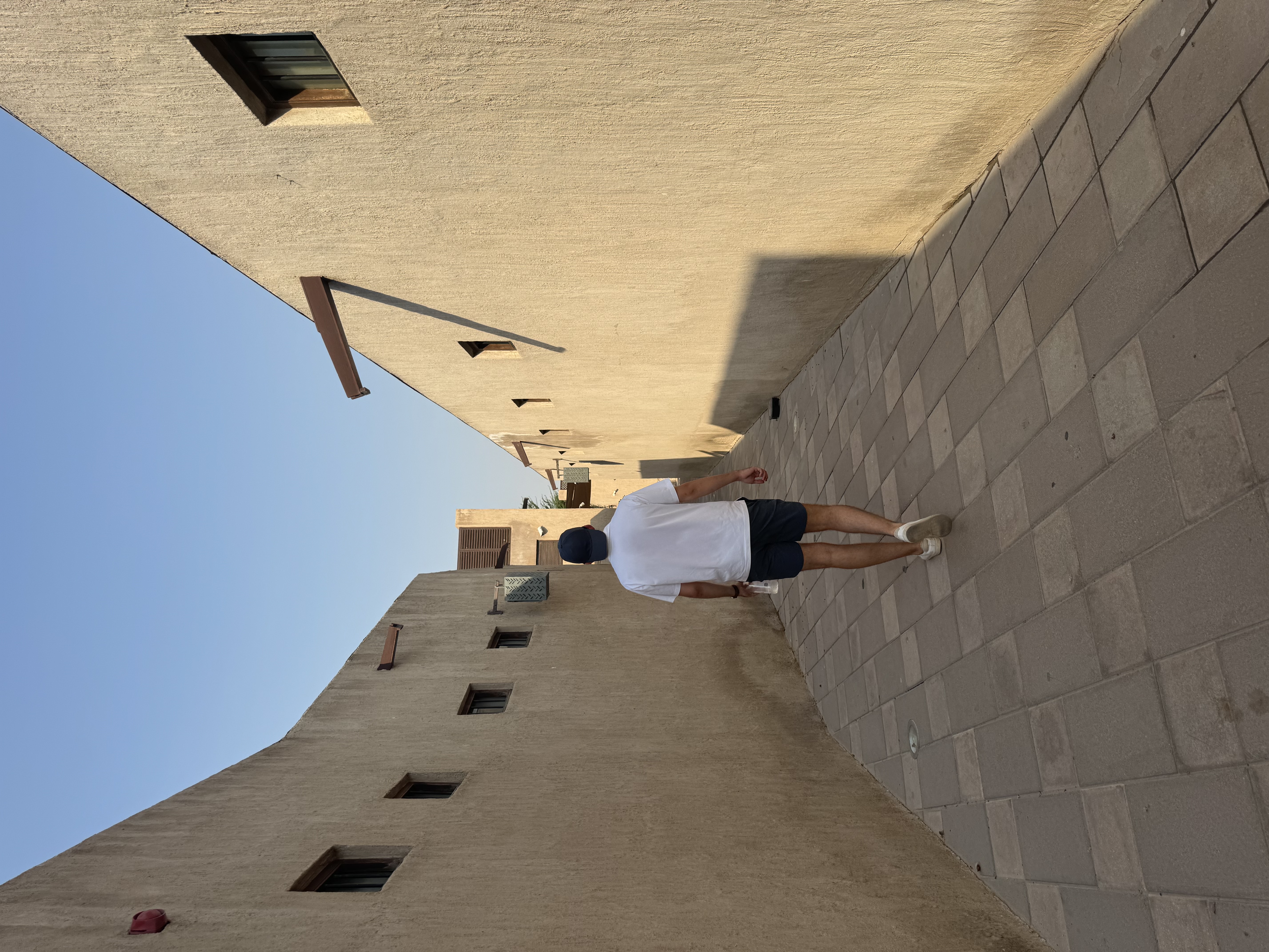 Walking down a narrow alley between sand-colored walls