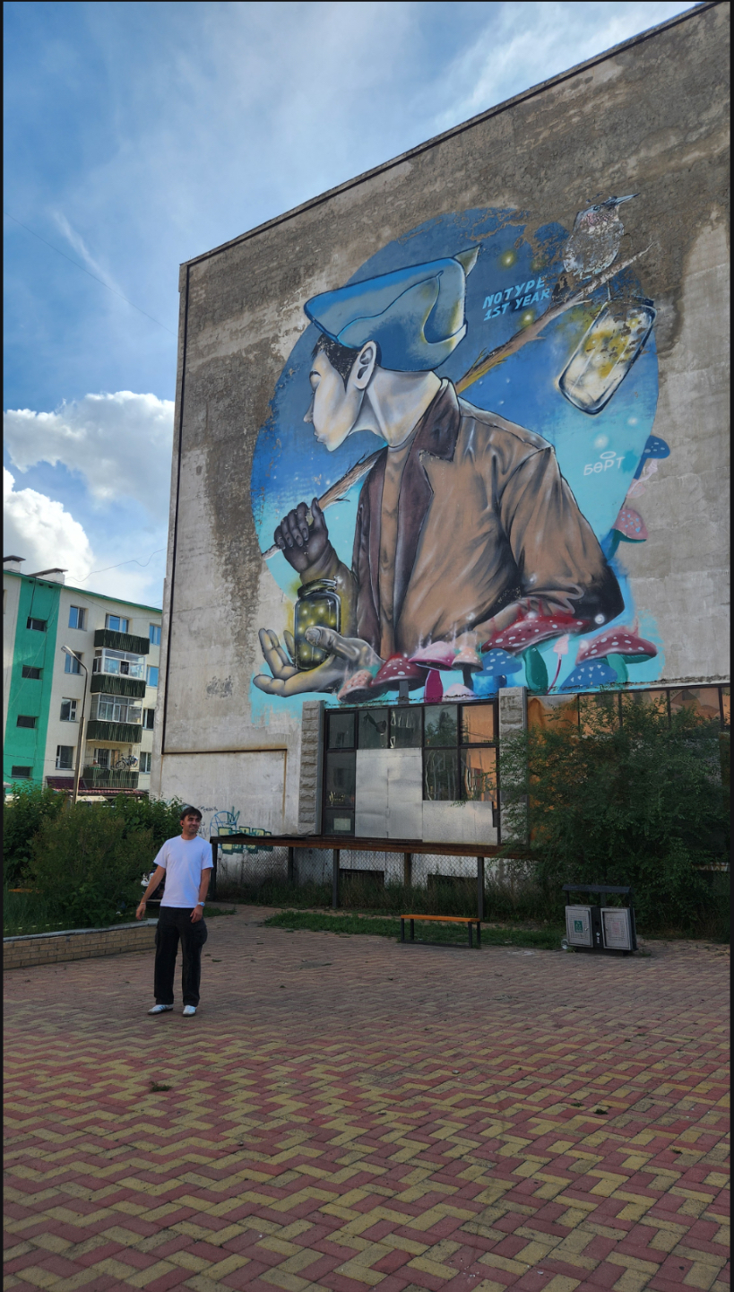 Standing in front of a large mural of a boy with fireflies