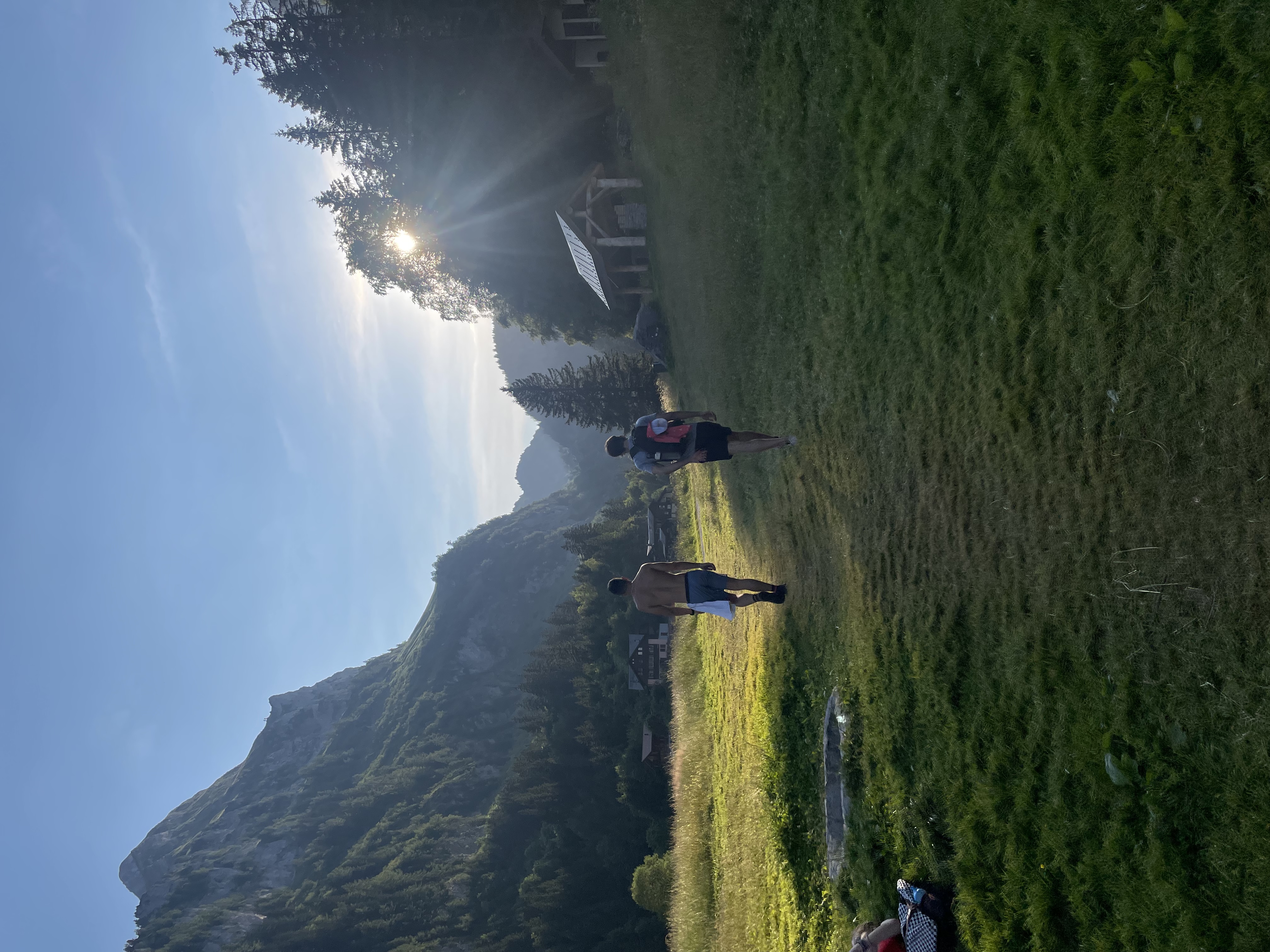 Two friends walking through a mountain valley at sunrise