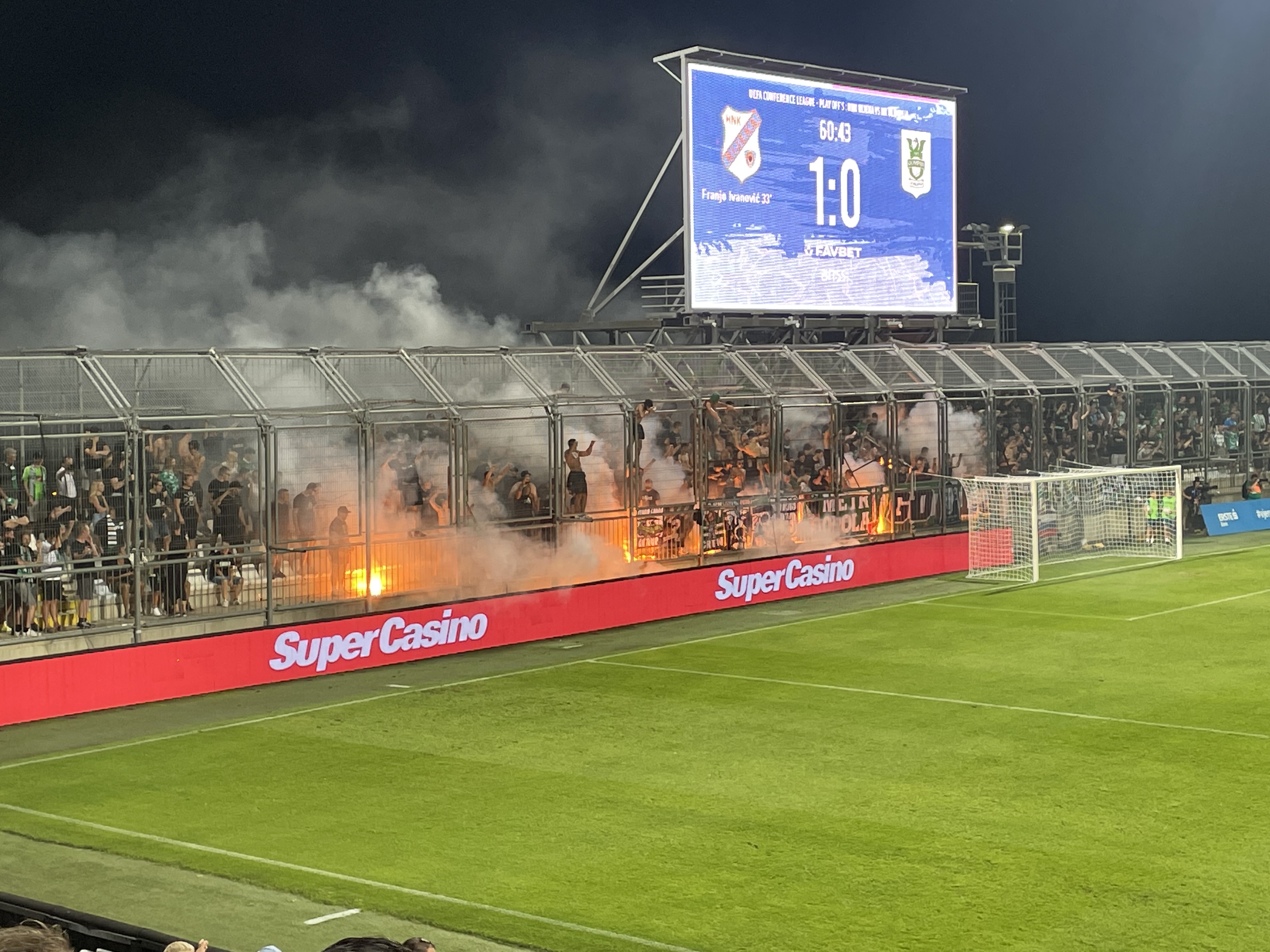 Flares and smoke in the stands at a night soccer match