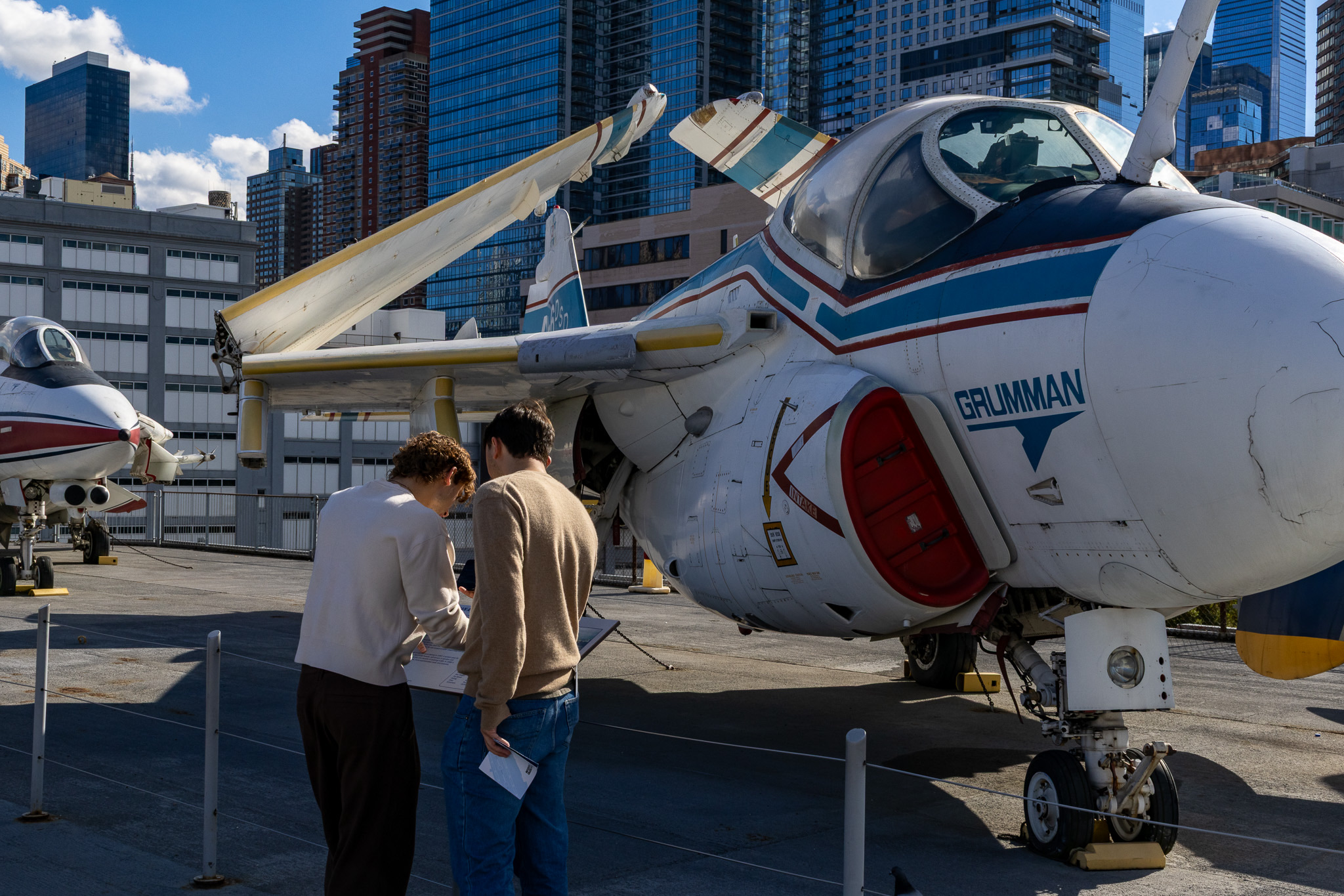 Examining a placard next to a jet on display